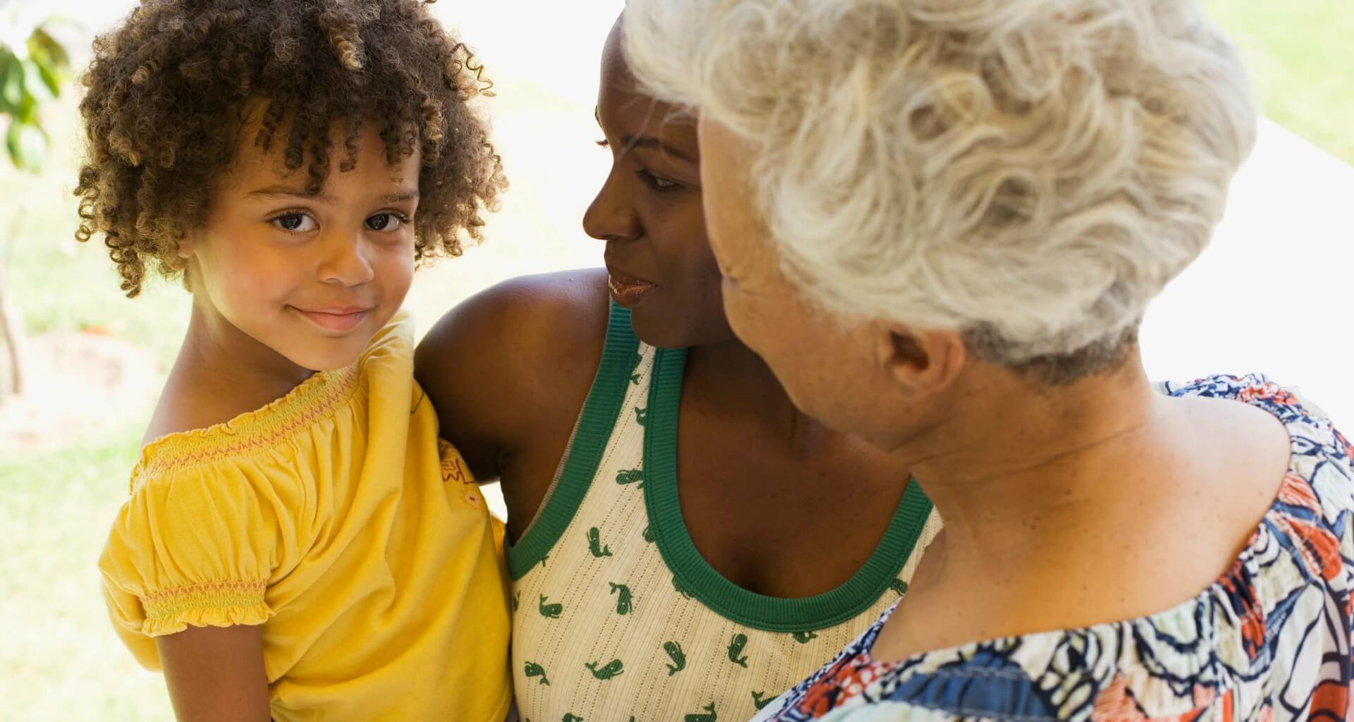 three generations of women, young child smiling at camera