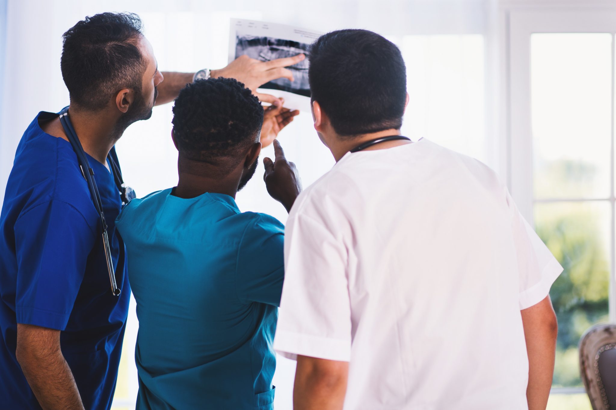 three doctors looking at an xray
