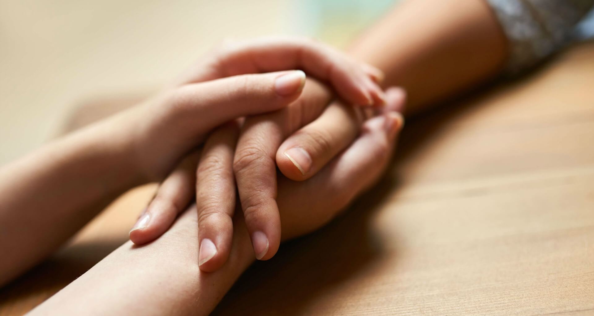 two people holding hands across a table