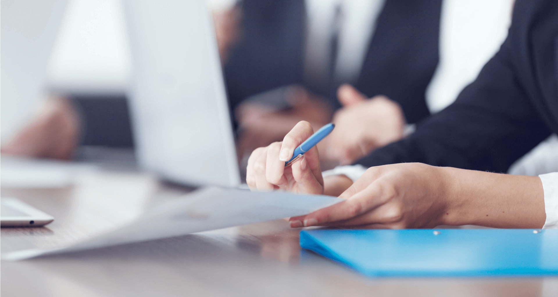 person holding paperwork and a pen