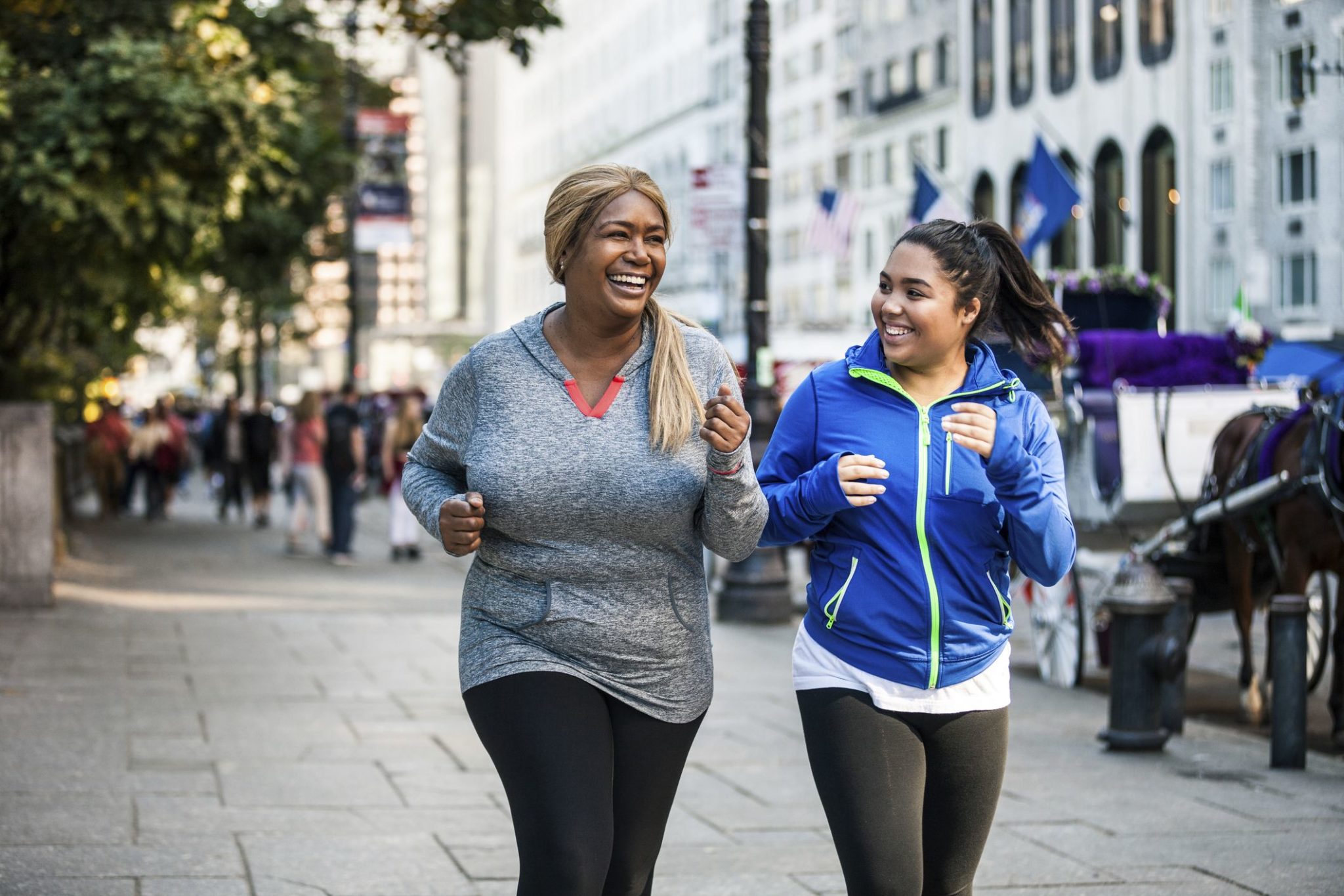 two women power-walking on a city street