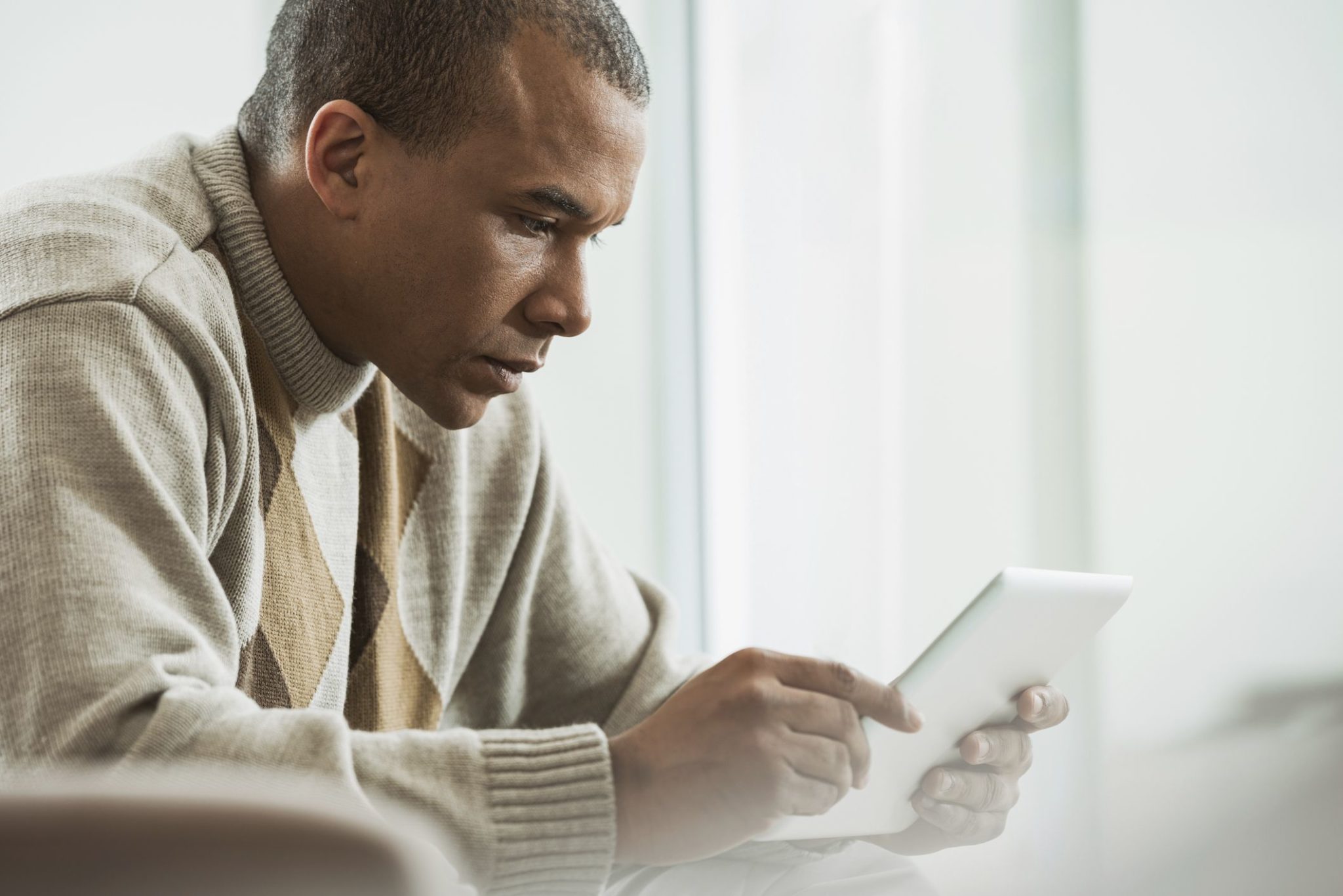 Older man using a tablet at home